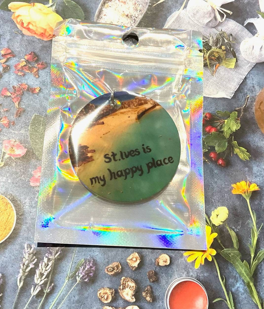 St. Ives is my happy place pendant in holographic packaging with botanical elements. 