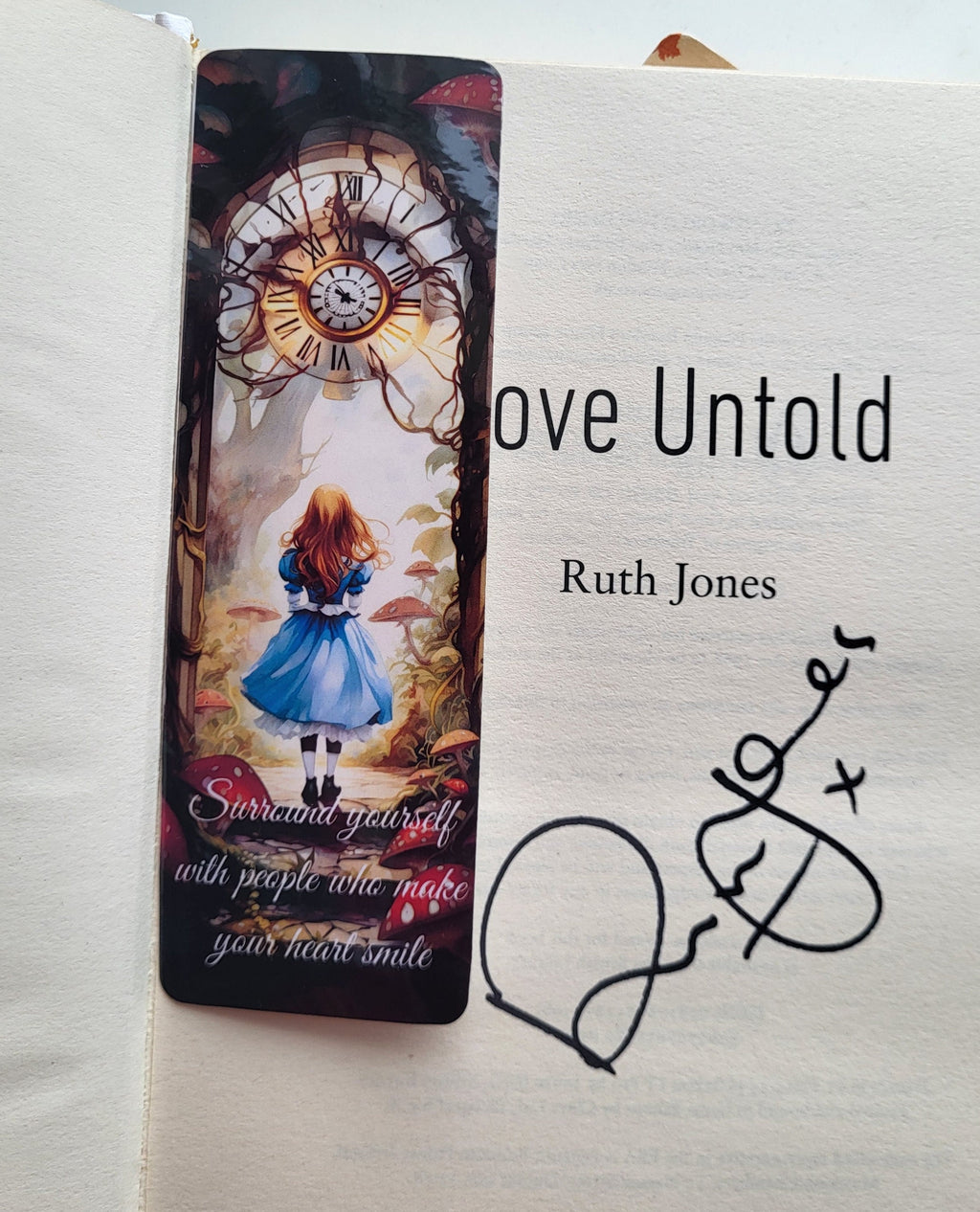 Signed book 'Love Untold' by Ruth Jones with Alice in Wonderland bookmark featuring inspirational quote.